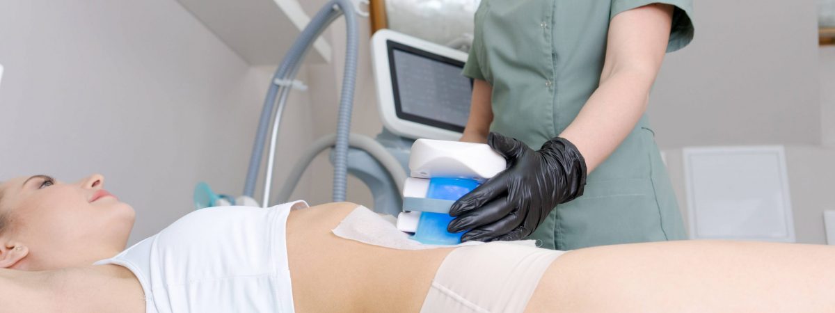 Young woman receives CryoliPolyse treatment in beauty parlour. Cool sculpting
